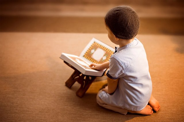 Child reading the Quran at home